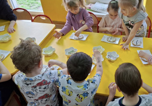 dzieci dekorują mazurki kolorową posypką