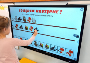 Dziecko uzupełnia sekwencję obrazków zwierząt na ekranie dotykowym w zadaniu „Co będzie następne?”.