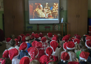 dzieci oglądają zyczenia od Mikołaja