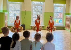 dziewczynki w strojach lisków czekąją na rozpoczęcie tańca