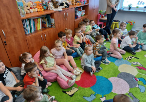dzieci siedzą w klasie na dywanie