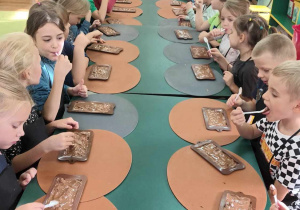 dzieci próbuja rozpuszczonej czekolady
