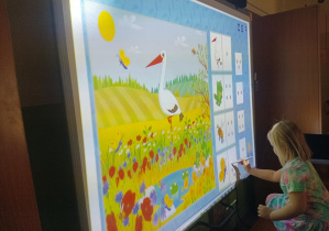 dziewczynka robi zadanie na tablicy interaktywnej