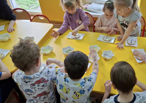 dzieci dekorują mazurki kolorową posypką