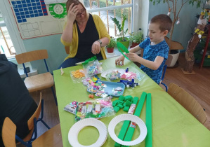 mama z chłopcem owijąją kartonowy okrąg bibuł