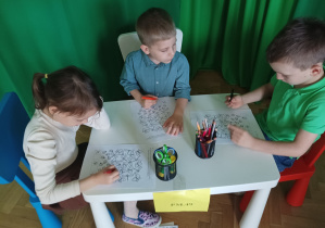 dzieczynka i chłopcy rozwiązują zadanie