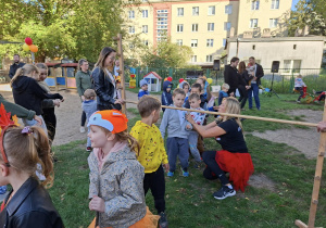 dzieci przechodzą pod poprzeczką