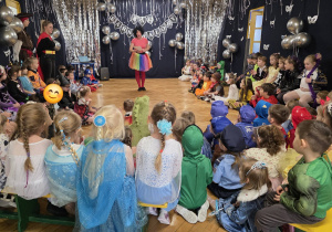 nauczycielka w przebraniu klauna wita dzieci na balu