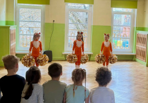 dziewczynki w strojach lisków czekąją na rozpoczęcie tańca