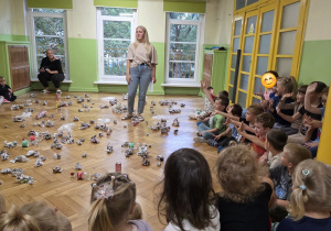 Dzieci siedzą w kręgu podczas zajęć edukacyjnych dotyczących ochrony środowiska i segregacji odpadów.