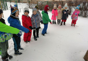 dzieci wskazuja ślady na śniegu